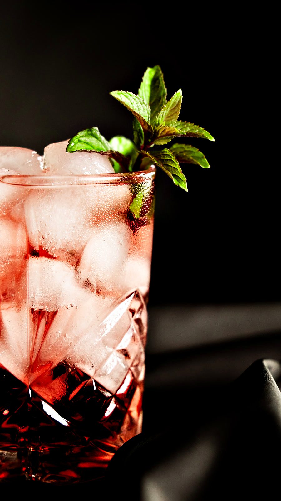 Cocktail rosso con menta su fondo nero
